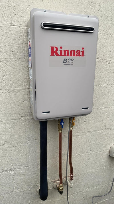 Rinnai B26 installed on a white brick wall | Featured image for Rinnai B16 (REU-A1624WB) + Installation Kit - 50 Degree